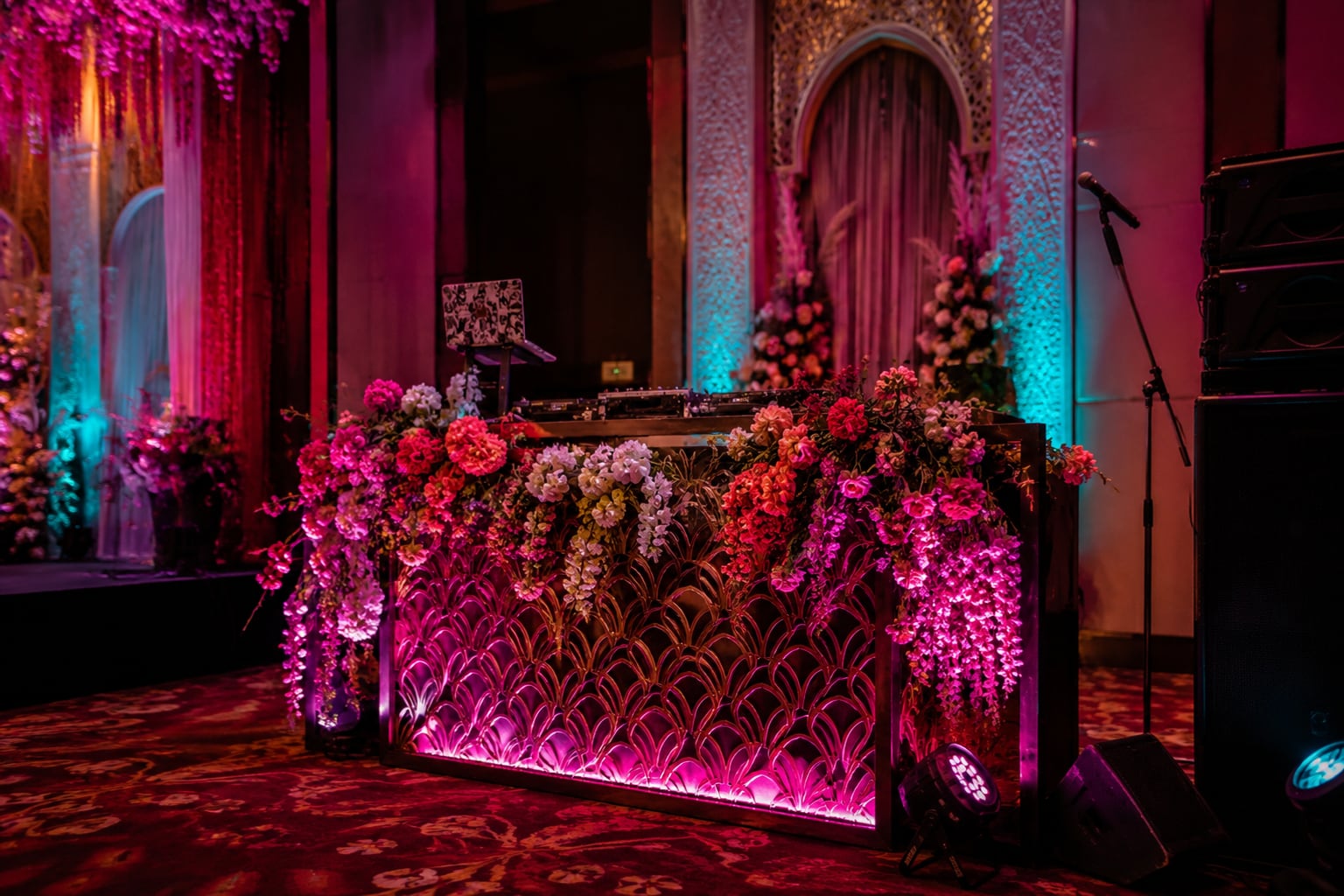 The DJ booth trimmed with the same floral work as the stage