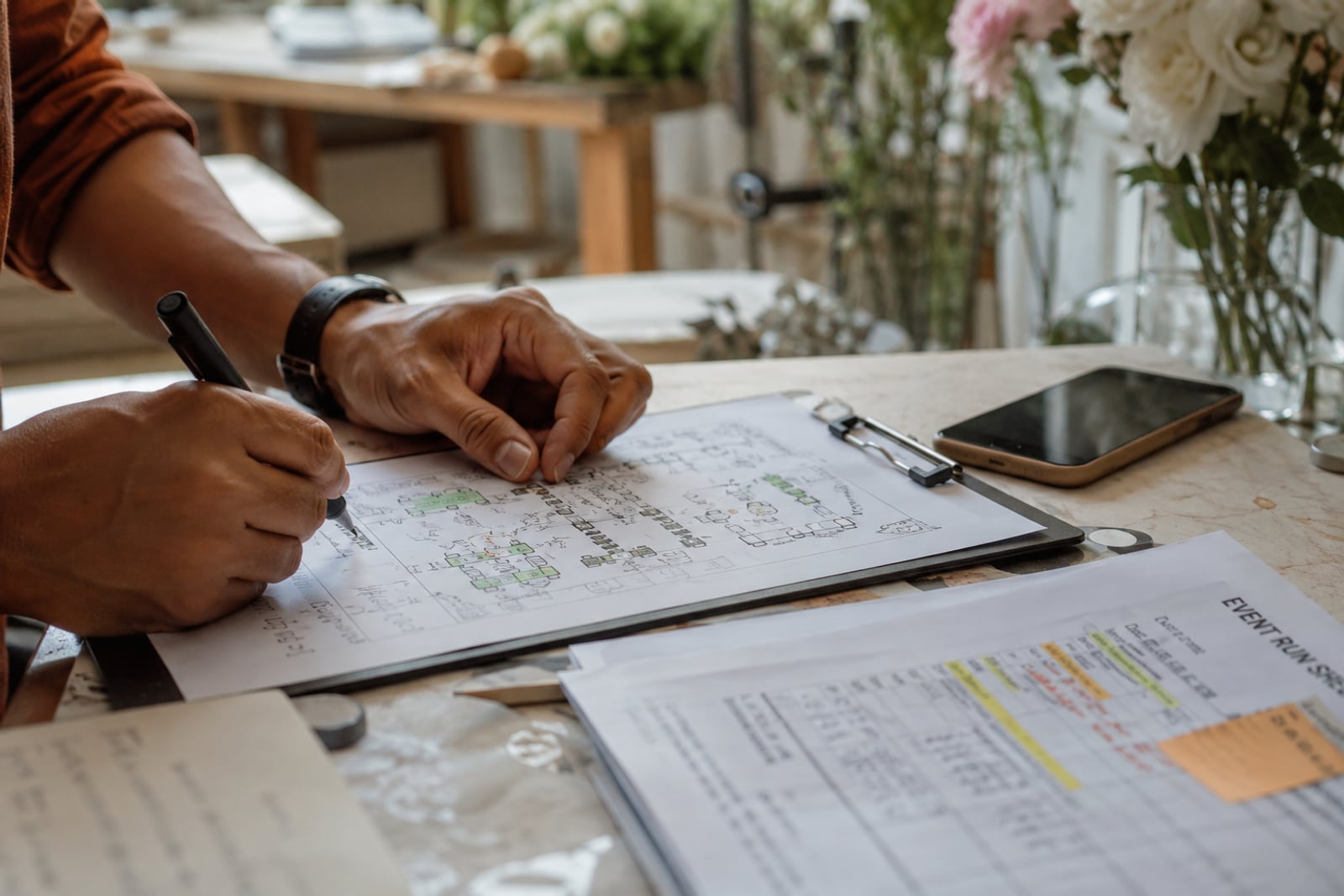 Marking up a seating chart, call sheets on the table